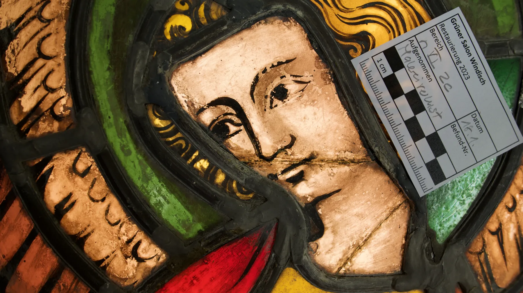 Detail einer historischen Glasmalerei mit Massstab